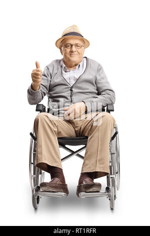 Full length portrait of a disabled senior man in a wheelchair looking at the camera and showing thumbs up isolated on white background Stock Photo