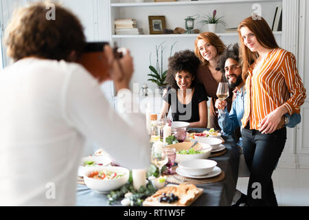 Friends taking a group picture as memory of a dinner party Stock Photo