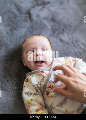 Mother tickling her laughing baby girl Stock Photo