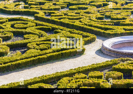 The parterre de broderie in the french formal garden of the castle of Auvers-sur-Oise with beds of boxwood pruned in geometrical shapes around a basin Stock Photo