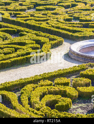 The parterre de broderie in the french formal garden of the castle of Auvers-sur-Oise with beds of boxwood pruned in geometrical shapes around a basin Stock Photo