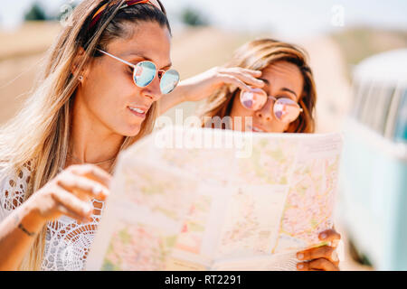 Two young women on roadtip orientating with map Stock Photo
