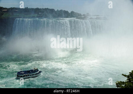 Niagara Horseshoe Falls with a touristic vessel Maid of the Mist approaching. The falls height is 57 m and they throw down about 6,400 m3 water per se Stock Photo