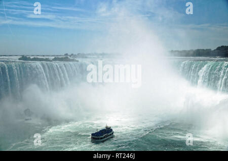 Niagara Horseshoe Falls with a touristic vessel Maid of the Mist approaching. The falls height is 57 m and they throw down about 6,400 m3 water per se Stock Photo