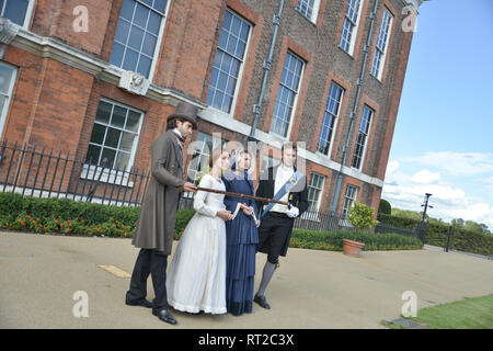 Queen Victoria, 2 gentlemen and her Baroness Lehzen stand in front of Kensington Palace and look at the grounds. Stock Photo