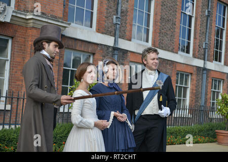 Queen Victoria, 2 gentlemen and her Baroness Lehzen stand in front of Kensington Palace and look at the grounds. Stock Photo