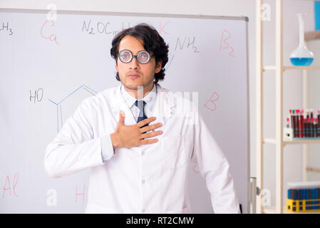 Young funny chemist in front of white board Stock Photo