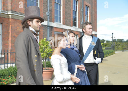 Queen Victoria, 2 gentlemen and her Baroness Lehzen stand in front of Kensington Palace and look at the grounds. Stock Photo