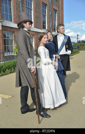 Queen Victoria, 2 gentlemen and her Baroness Lehzen stand in front of Kensington Palace and look at the grounds. Stock Photo