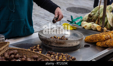 Street food. Roasting and selling sweet corns and chestnuts at Ermou street Athens, Greece. Stock Photo