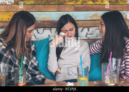Friends supporting and consoling crying young woman Stock Photo