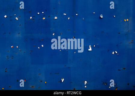 An Empty Blue Notice Board With Drawing Pins And Staples And The Ghost Images Of Past Notices Stock Photo
