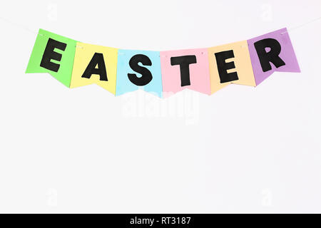 Diy Easter garland bunnies, flags with letters EASTER made of multicolor paper on a white wall background. Gift idea, decor Spring, Easter. kid childr Stock Photo
