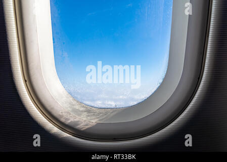 The window of the airplane. A view of porthole window on board an airbus for your travel concept or passenger air transportation Stock Photo