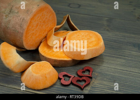 Sliced sweet potato Ipomoea batatas in close up on dark rustic table background Stock Photo