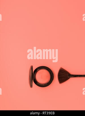 Brush for applying decorative makeup and blush eye shadow on a delicate pink background. Care and beauty concept. Minimalism. Stock Photo