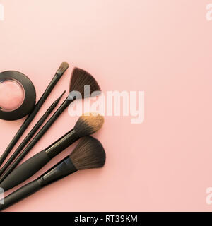 Various small brushes small for applying decorative makeup on a delicate pink background. Care and beauty concept. Stock Photo
