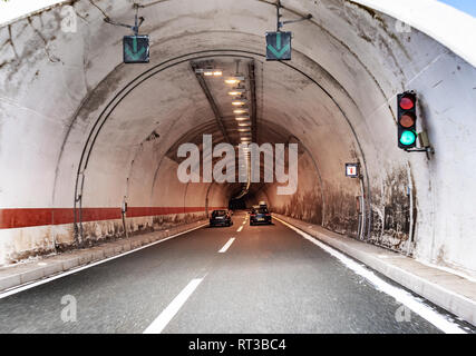 Cars move in a tunnel through a mountain on a freeway. Stock Photo