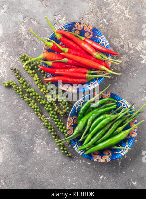 Different varieties of hot pepper on a gray textured background. East Asian food concept. Flat layout. Stock Photo