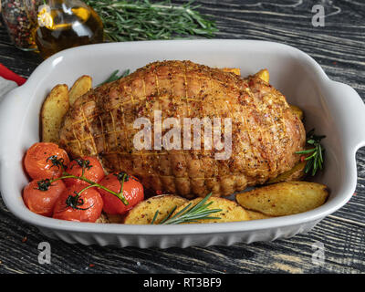 Roasted pork meat roulade, roll with potato and tomato in baking tray Stock Photo