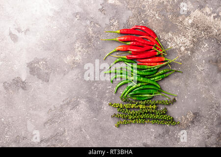 Different varieties of hot pepper on a gray textured background. East Asian food concept. Flat layout. Stock Photo