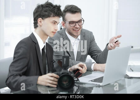 qualified photographers choose photos to upload files to their laptops Stock Photo