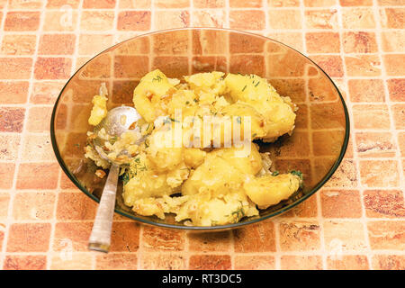 Potatoes with a spoon in a plate on table Stock Photo