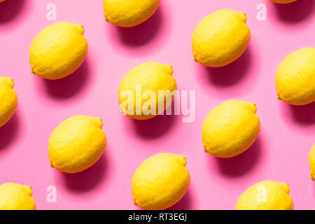 Yellow lemons on pink background Stock Photo
