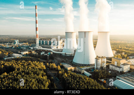 A Power plant with white smoke over it's chimneys Stock Photo