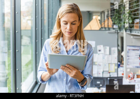 Woman using tablet in office Stock Photo