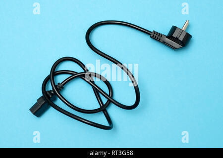 Black power cable line for computer on blue background. Top view. Stock Photo