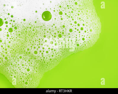 Soap sud on green background. Shampoo in water. Soap foam with bubbles. Flat lay. Stock Photo
