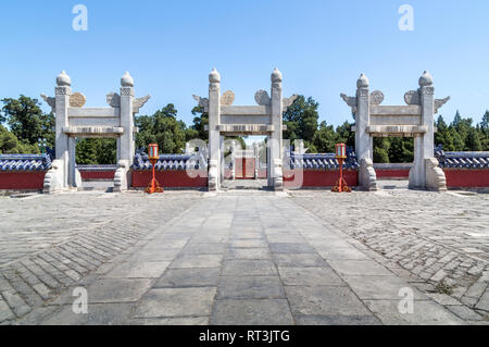 Linxing Gate of the Circular Mound Altar shown without any people in the shot. Three white marble gates stand out  amid the red walls and blue tiles. Stock Photo