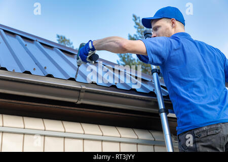 metal roofing - roofer working on the house roof Stock Photo