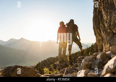 Couple standing on a mountain, looking at view Stock Photo