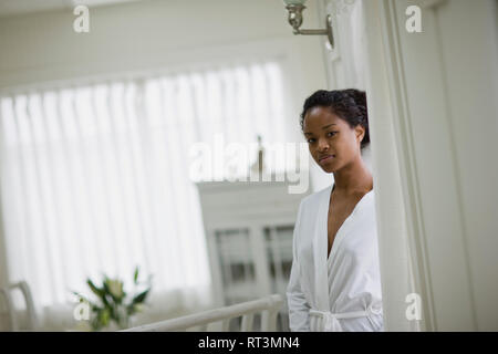 Portrait of a young woman wearing a white robe inside her home. Stock Photo