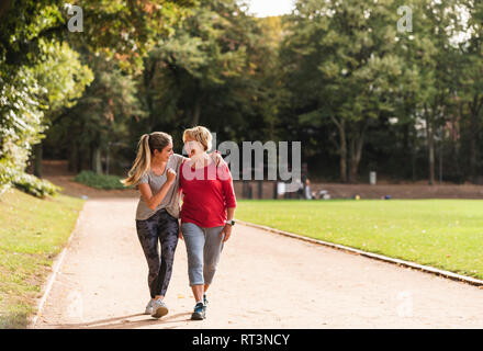 Granddaughter and grandmother having fun, jogging together in the park Stock Photo