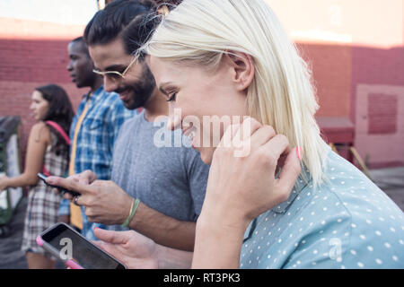 Young people using cell phones outdoors Stock Photo