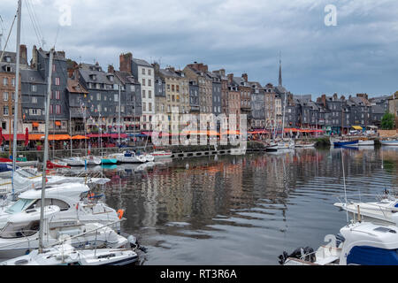 Honfleur Harbour, showing French restaurants around the harbour. Boats are also shown in this French harbour near the river Seine. Stock Photo