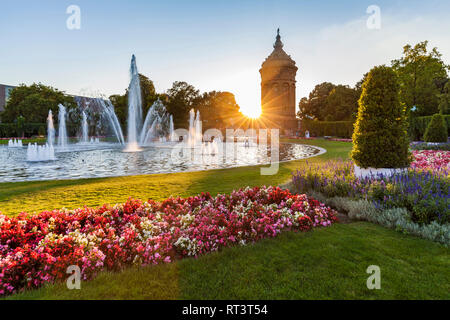 Germany, Mannheim, Friedrichsplatz with fountain and water tower in the background by sunset Stock Photo