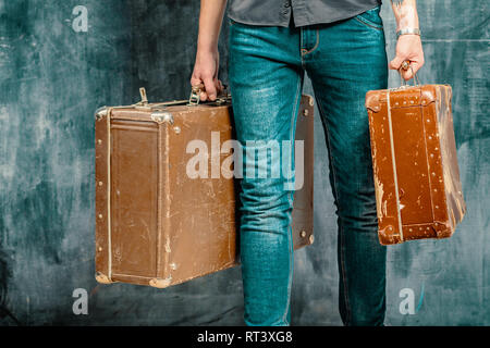 A man carries two old plywood cases with scratches Stock Photo