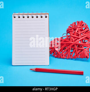 open blank notebook in line and red heart on a blue background Stock Photo