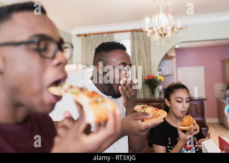 Teenage siblings eating pizza Stock Photo