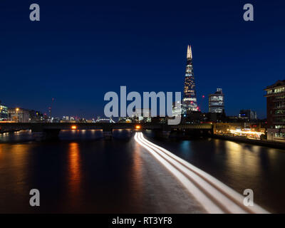 A shot of The Shard in London with the light trails from a rescue boat going up the Thames at Blue Hour. Stock Photo