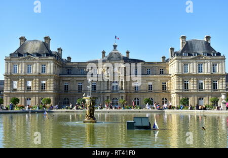 Luxembourg Palace with the french flag, pond and fountain. Latin Quarter, Luxembourg Gardens, Paris, France, 15 Aug 2018. Stock Photo