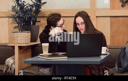 Cheerful girls discussing creative ideas for freelance startup in friendly atmosphere Stock Photo