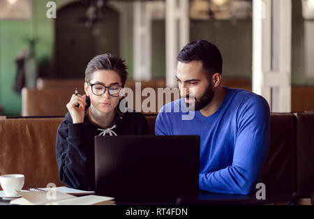 Students talking with each other planning startup strategy during meeting at the cafe Stock Photo