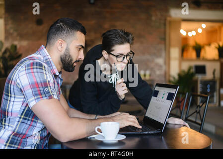 Two clever students having discussion about studying while sitting at the cafe Stock Photo