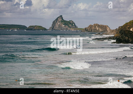 Professional surfers surfing the worldclass waves of Fernando de Noronha, an Island off the North Coast of Brazil Stock Photo
