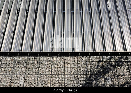 Gabion wall and vertical stainless steel mesh cladding on multi storey car park in bury town centre in lancashire uk Stock Photo